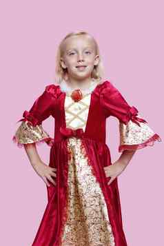 肖像快乐年轻的女孩穿着公主服装粉红色的背景