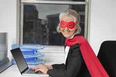 肖像高级女商人超级英雄服装移动PC办公室桌子上
