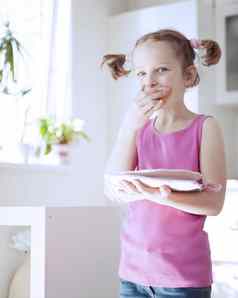 年轻的女孩吃蛋糕厨房