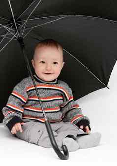 婴儿男孩坐着伞