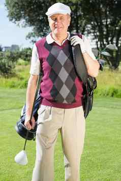 高尔夫球手携带高尔夫球袋微笑相机