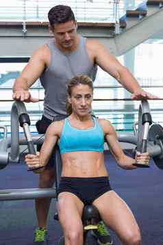 个人教练训练女健美运动员重量机