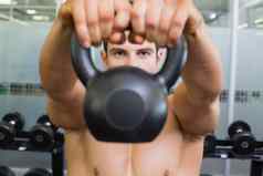 肌肉发达的男人。提升水壶贝尔健身房