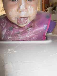舌头婴儿脏脸白色酸奶高脚凳四周散落