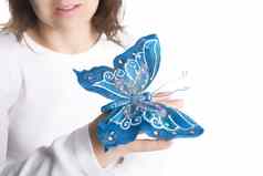 年轻的女人持有蓝色的蝴蝶