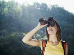 年轻的女人徒步旅行双筒望远镜