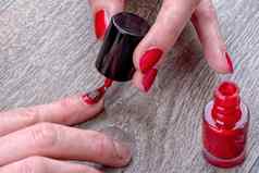 女手绘画红色的指甲清漆