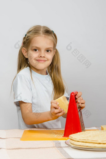 六年女孩摆姿势厨房表格奶酪刨丝器手