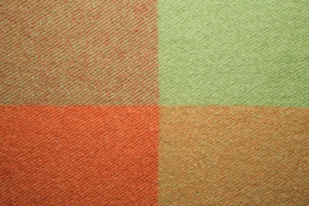 软温暖的折叠羊驼羊毛毯子绿色橙色羊毛格子纹理宏拍摄羊毛格子纹理羊毛毯子