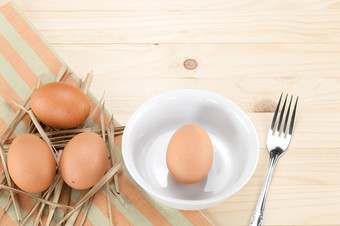 新鲜的鸡蛋浓密的头发蛋碗叉木背景