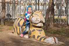 快乐女孩坐着雕塑老虎操场上阿纳帕