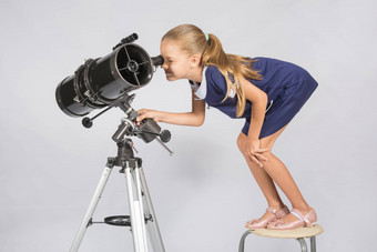 七年女孩站椅子荒谬的目镜望远镜反射器