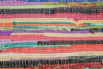色彩斑斓的地毯纹理手工制作的地毯关闭美丽的手使地毯