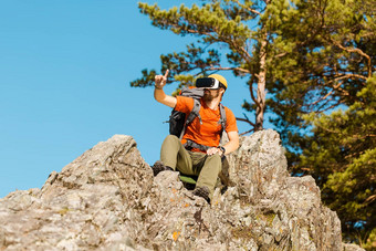 成功的年轻的男人。虚拟现实护目镜之旅山假期夏天