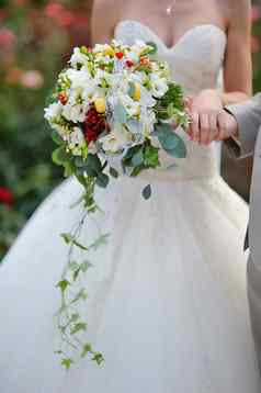 新娘持有婚礼花束色彩斑斓的花玫瑰