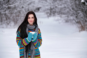 美丽的年轻的女人毛衣冬天在户外走