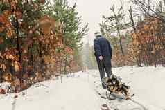 男人。携带木雪橇冬天雪森林