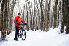 山骑摩托车的人自行车雪小道美丽的冬天森林