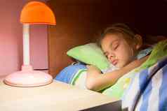七年女孩睡着了床上阅读灯包括表格