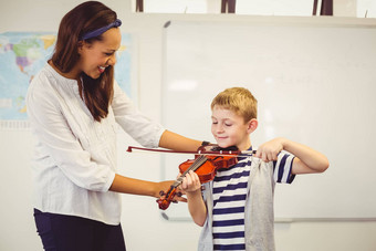 老师协助小学生玩小提琴教室