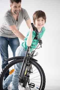 快乐的父亲教学儿子骑自行车白色