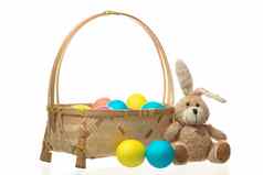 泰迪兔子篮子色彩斑斓的复活节鸡蛋孤立的