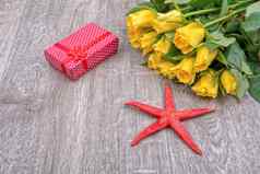 黄色的玫瑰红色的礼物红色的海星木背景