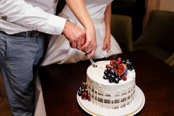 新婚夫妇减少<strong>婚礼蛋糕</strong>装饰新鲜的水果新娘新郎减少<strong>婚礼蛋糕</strong>