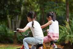 活跃的亚洲孩子们骑自行车户外