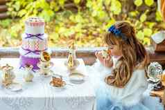 一边视图美丽的女孩风景爱丽丝仙境喝茶表格公园