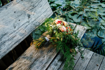 郁郁葱葱的婚礼花束灰色的木板凳上水水莉莉