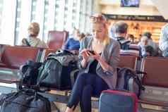 女旅行者细胞电话等待机场