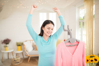 快乐年轻的亚洲女人完成热气腾腾的衣服房间