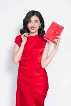 漂亮的年轻的亚洲女人穿着红色的衣服现在