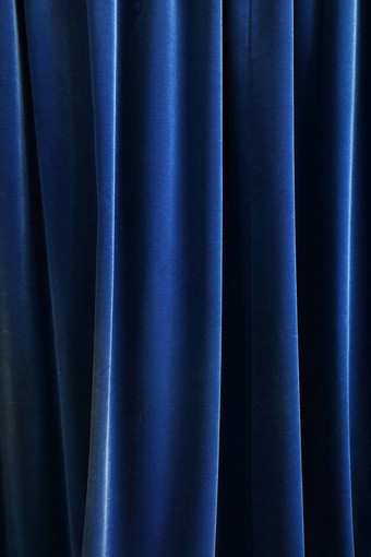 重黑暗蓝色的打褶的纺织窗帘背景