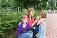 家庭坐着夏天公园吃冰淇淋