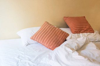 白色枕头橙色枕头床上皱纹混乱的等等