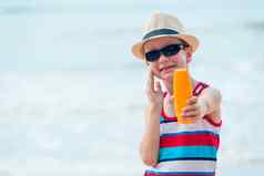 一年男孩显示保护太阳奶油涂片滑雪