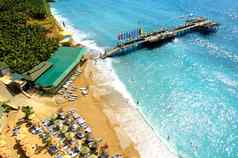 空中视图美丽的夏天海滩人蓝色的海码头雨伞旅行假期概念