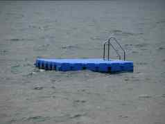 孤立的蓝色的浮桥游泳平台狂风暴雨的水
