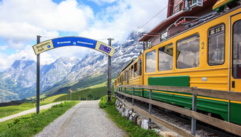 标志开始点开始走小道视图瑞士温格纳尔普缆车铁路火车离开小谢德格站》<strong>剧组</strong>瑞士走小道绿色新鲜的草地雪封顶山背景