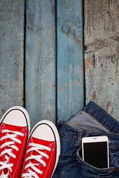 红色的复古的运动鞋智能手机牛仔裤口袋里蓝色的