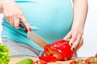 特写镜头怀孕了女人的手准备沙拉vegetab