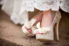 美丽的白色奶油花边婚礼鞋子
