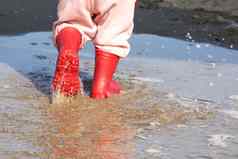 高统靴水坑孩子橡胶靴子海背景