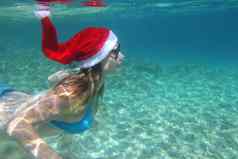 女人圣诞老人他游泳水下