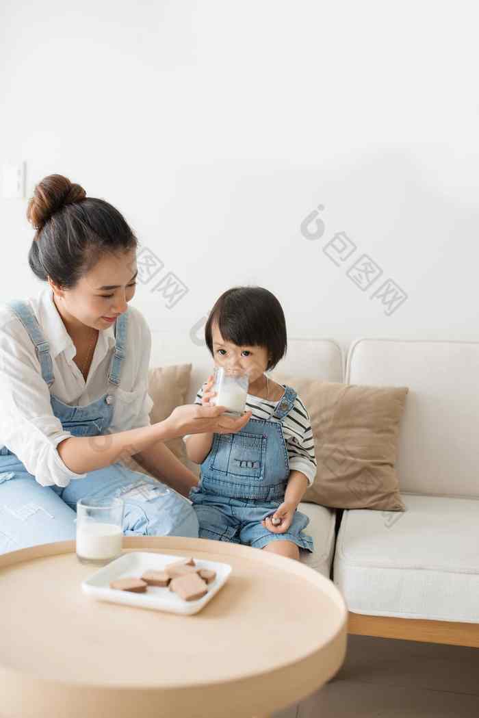 快乐家庭亚洲妈妈喝牛奶可爱的daughte