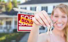 兴奋女人持有房子键出售出售真正的房地产标志前面不错的首页