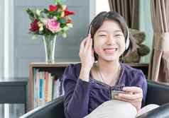 年轻的亚洲女人短头发听音乐生活房间