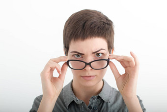 年轻的女人穿眼镜眼镜女人显示眼镜快乐持有眼镜框架特写镜头年轻的高加索人女人